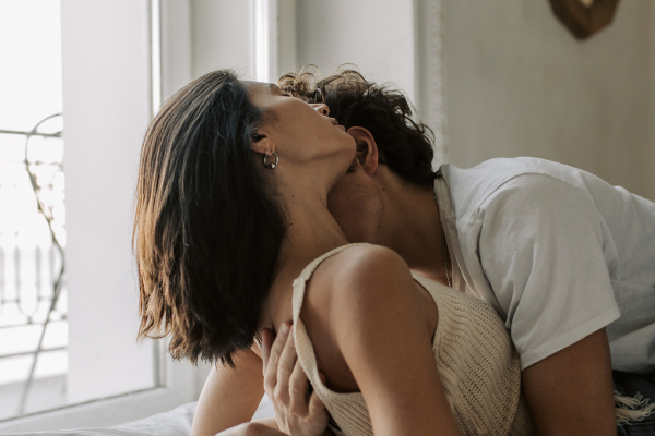 Homem beijando mulher no pescoço