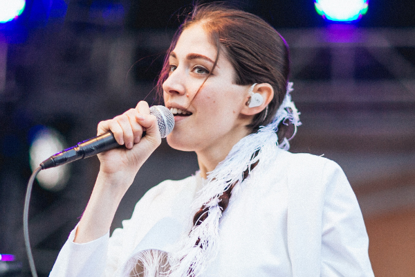 Imagem da cantora Caroline Polachek cantando em um show