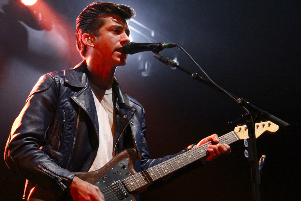 Imagem do cantor Alex Turner, vocalista da banda Arctic Monkeys, cantando no show