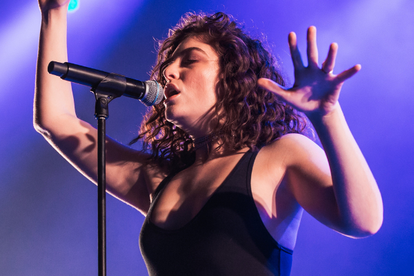 Imagem da cantora Lorde cantando em um show