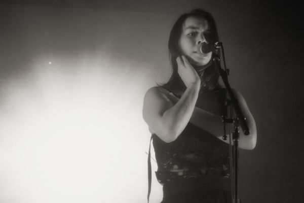 Imagem da cantora Mitski cantando durante show