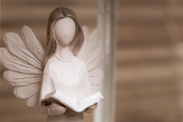 Imagem da estátua de um anjo segurando uma Bíblia