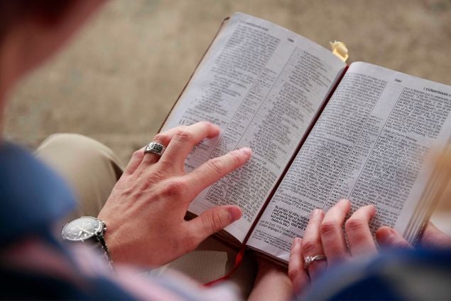 Bíblia, sendo lida por duas pessoas