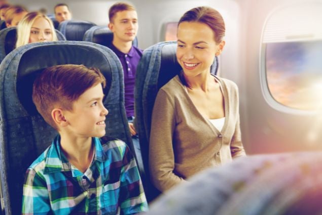 Imagem de um garoto dentro de um avião viajando com os seus amigos.