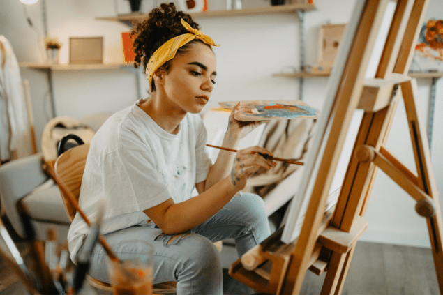 Mulher sentada pintando um quadro