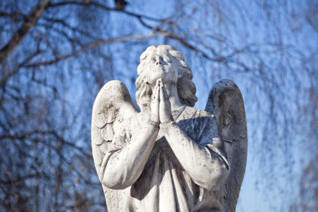 Estátua de anjo representando Harahel. Ele está com as mãos juntas olhando ao céu enquanto reza. 