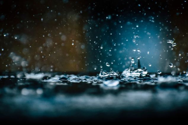 Imagem da água da chuva caindo no chão mostrada bem de perto