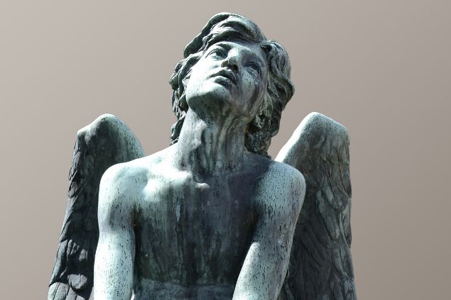 Imagem da estátua de um anjo sentado e olhando para cima