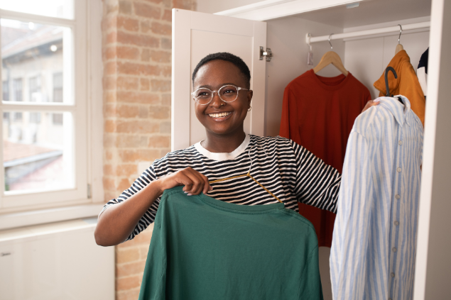 Mulher organizando o guarda roupa enquanto sorri