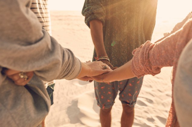 Amigos de mãos dadas na areia